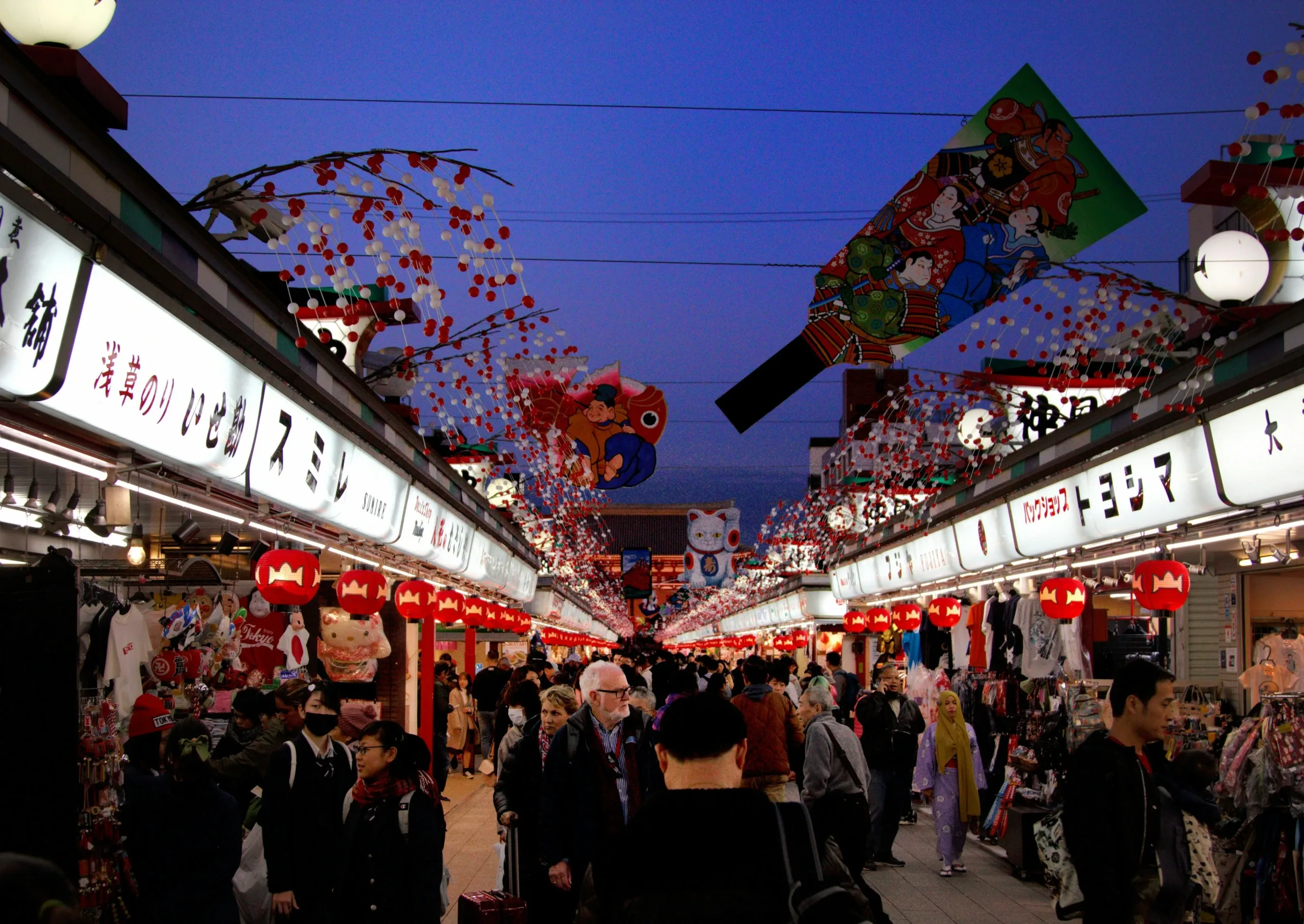 Visitors walk between the shopfronts on Nakamise-dori toward Senso-ji in Tokyo’s Asakusa district.